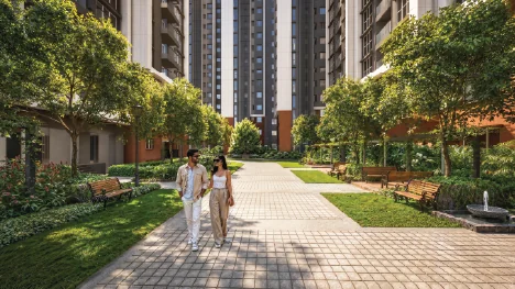 Artist's impression of the central spine at Godrej Brooklyn Avenue: a brick-paved promenade lined with mature trees, lawns and benches, running between residential towers.